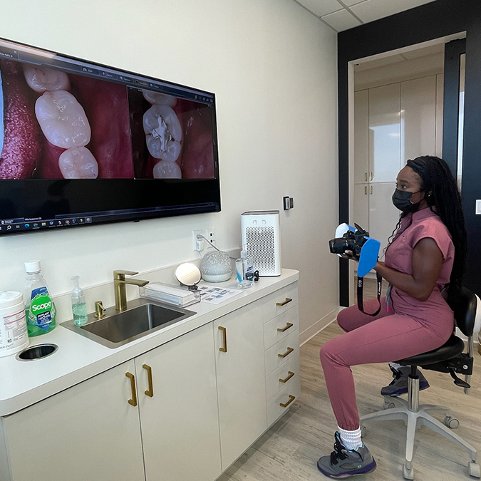 Dr. Ijeoma Igwe examing photos of teeth.